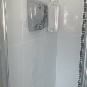 Close up of shower of white shower tiles and grouted cleaned